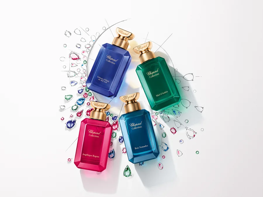 Ақ фонда түрлі түсті тастардың арасындағы төрт Chopard Collection құтысы