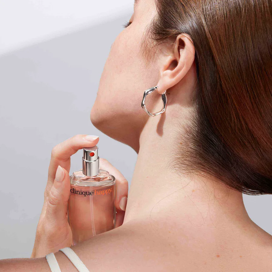 Қыз Clinique Happy хош иісін себуде