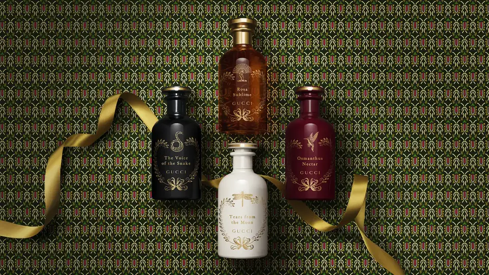 Өрнекті фондағы алтын таспалы Gucci The Alchemist's Garden коллекциясының төрт құтысы