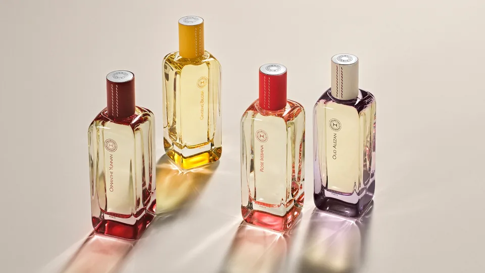 Ашық фондағы түрлі түсті көлеңкелердегі Hermès Hermessence коллекциясының төрт құтысы